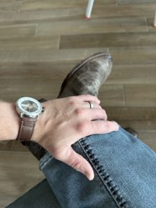 Timeless Swiss watch next to Western cowboy boot